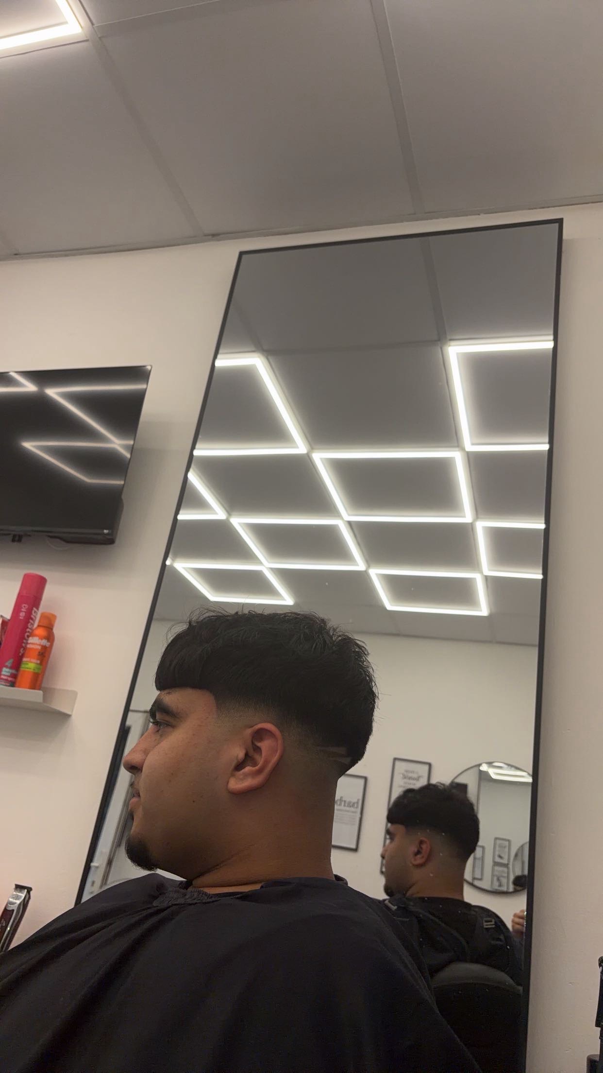 Low taper fade, side profile in the mirror
